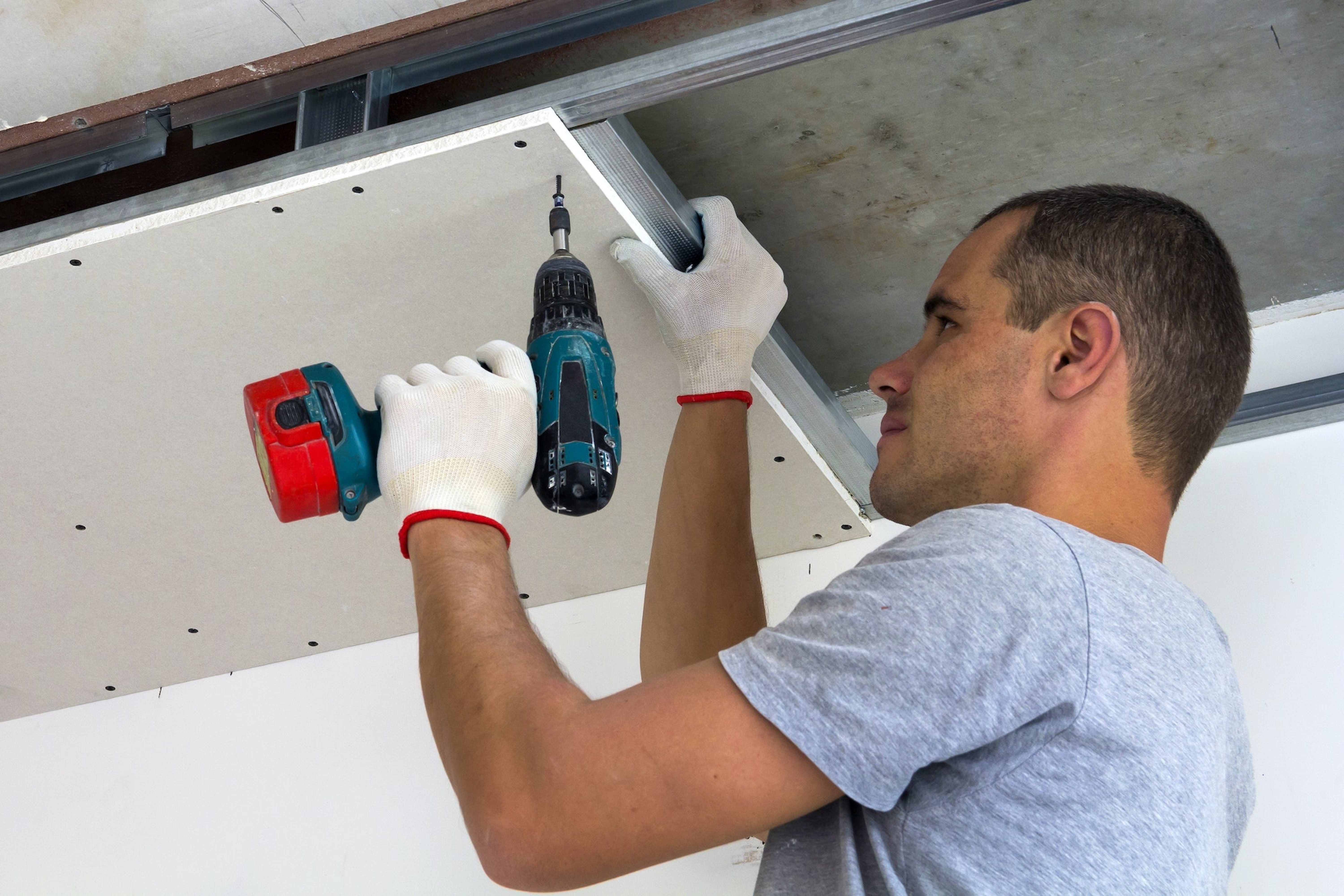 Construction worker assemble a suspended ceiling with drywall anchor 