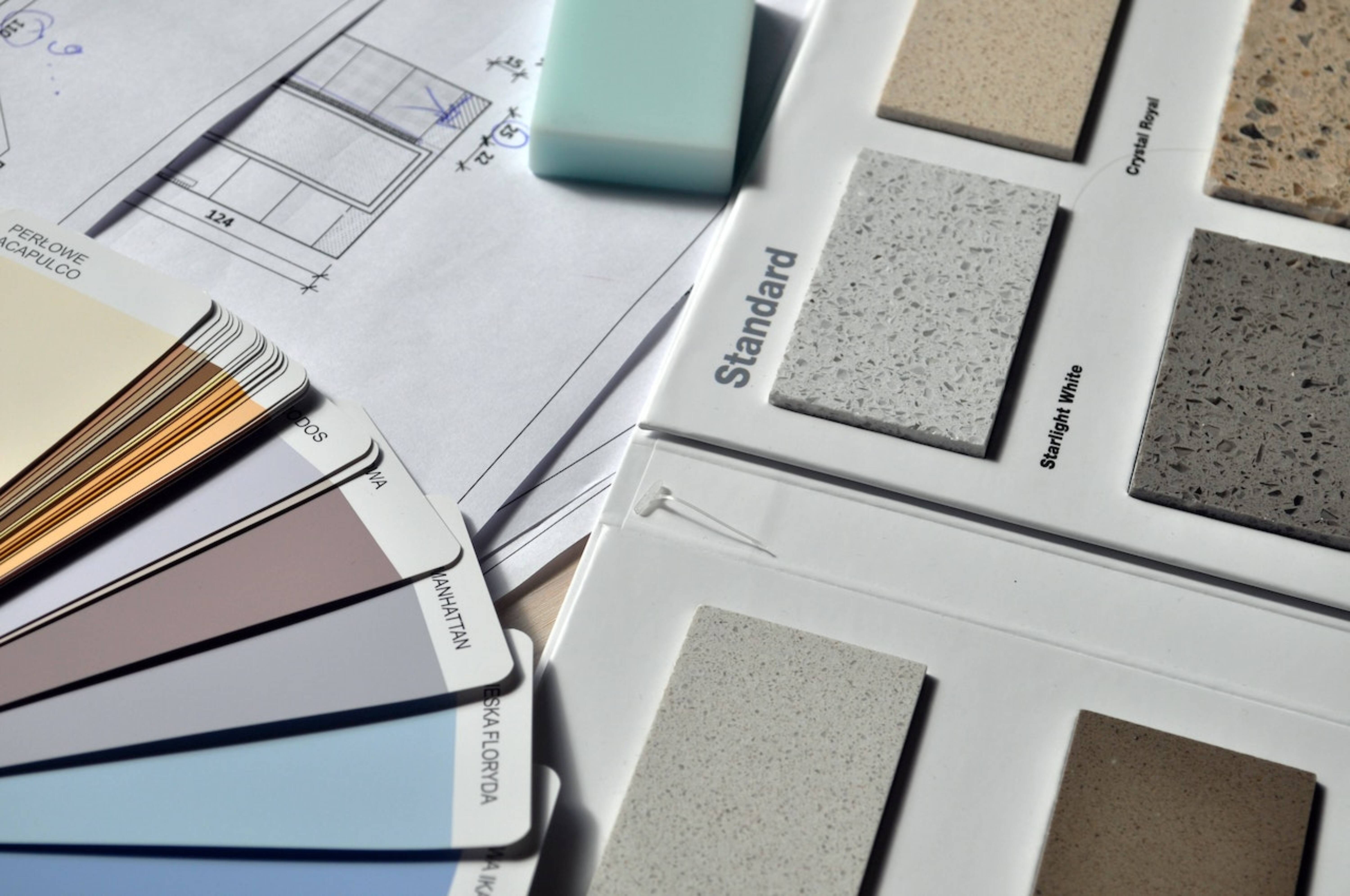 A selection of paint samples on a table, which are essential when choosing the perfect stucco color.