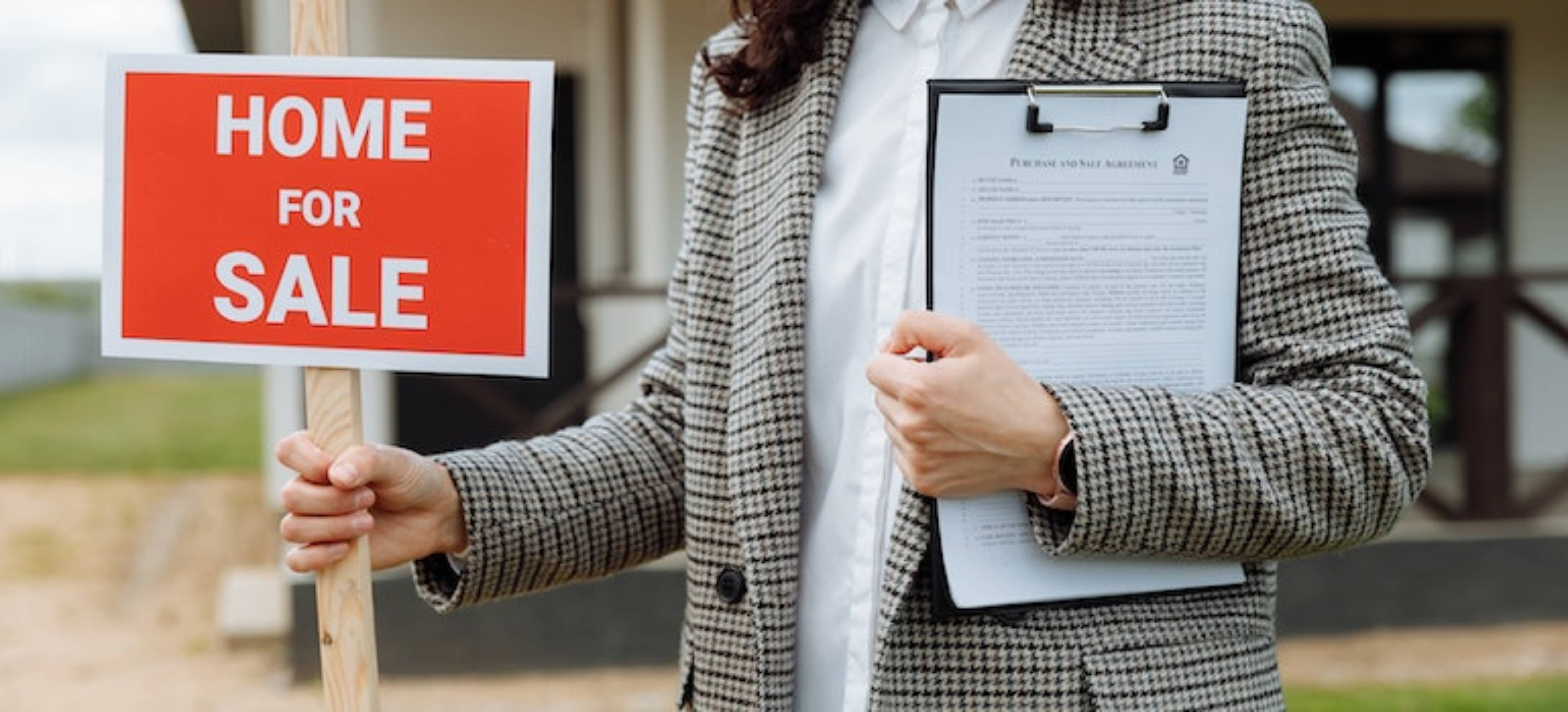 a real estate agent with a home for sale sign