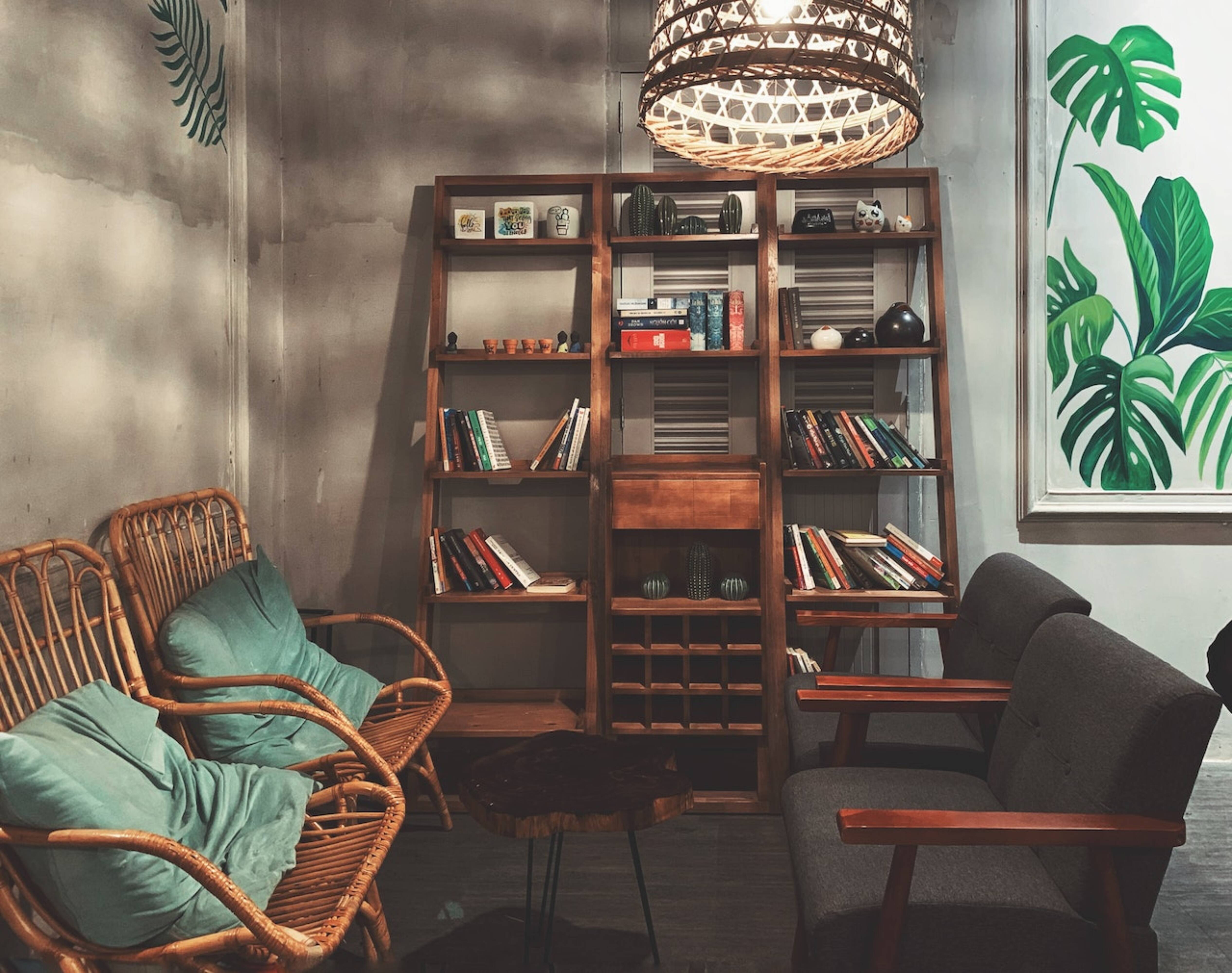 Chairs, a table, and a bookcase in a living room.