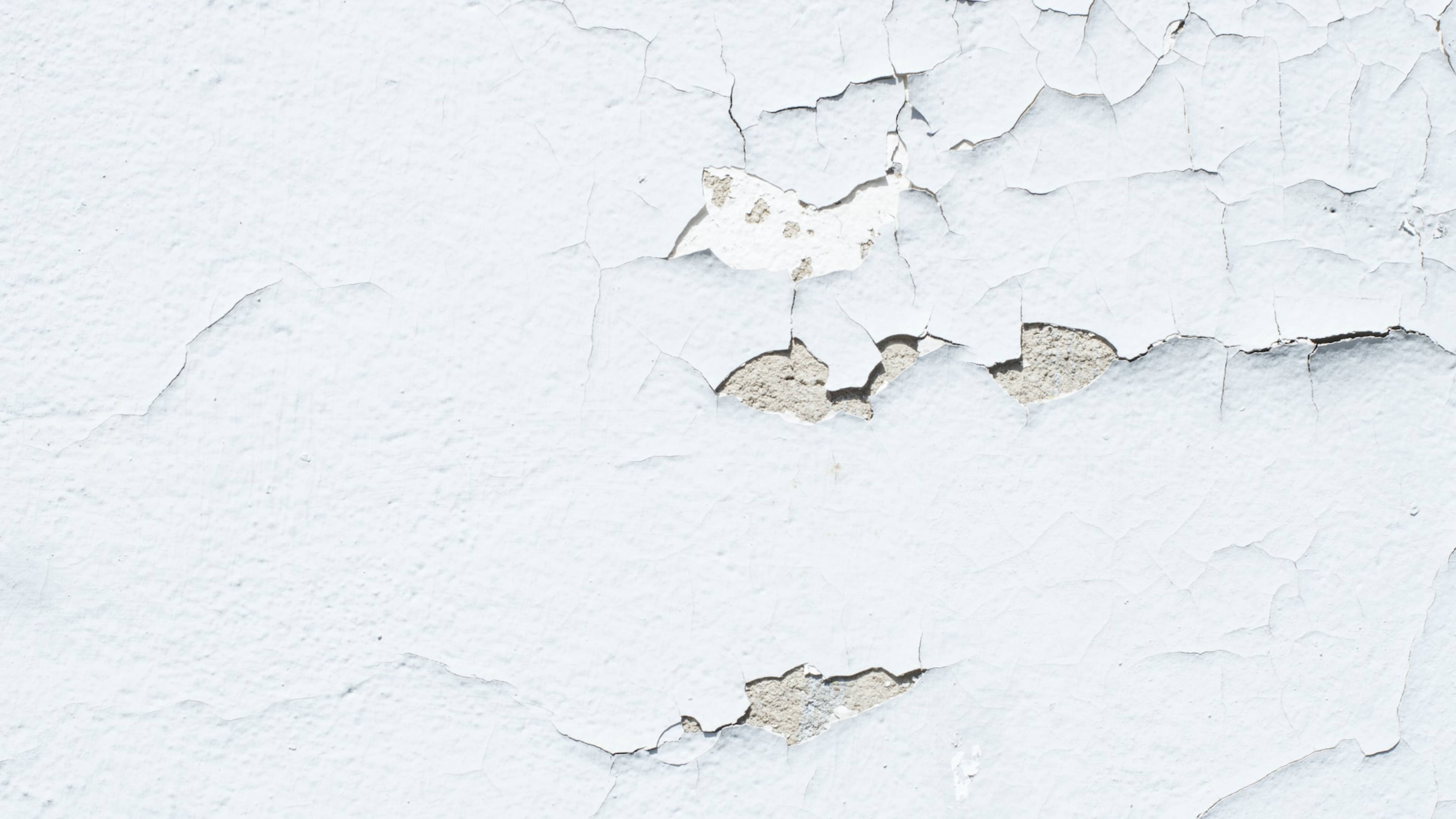 A white wall with cracks in it