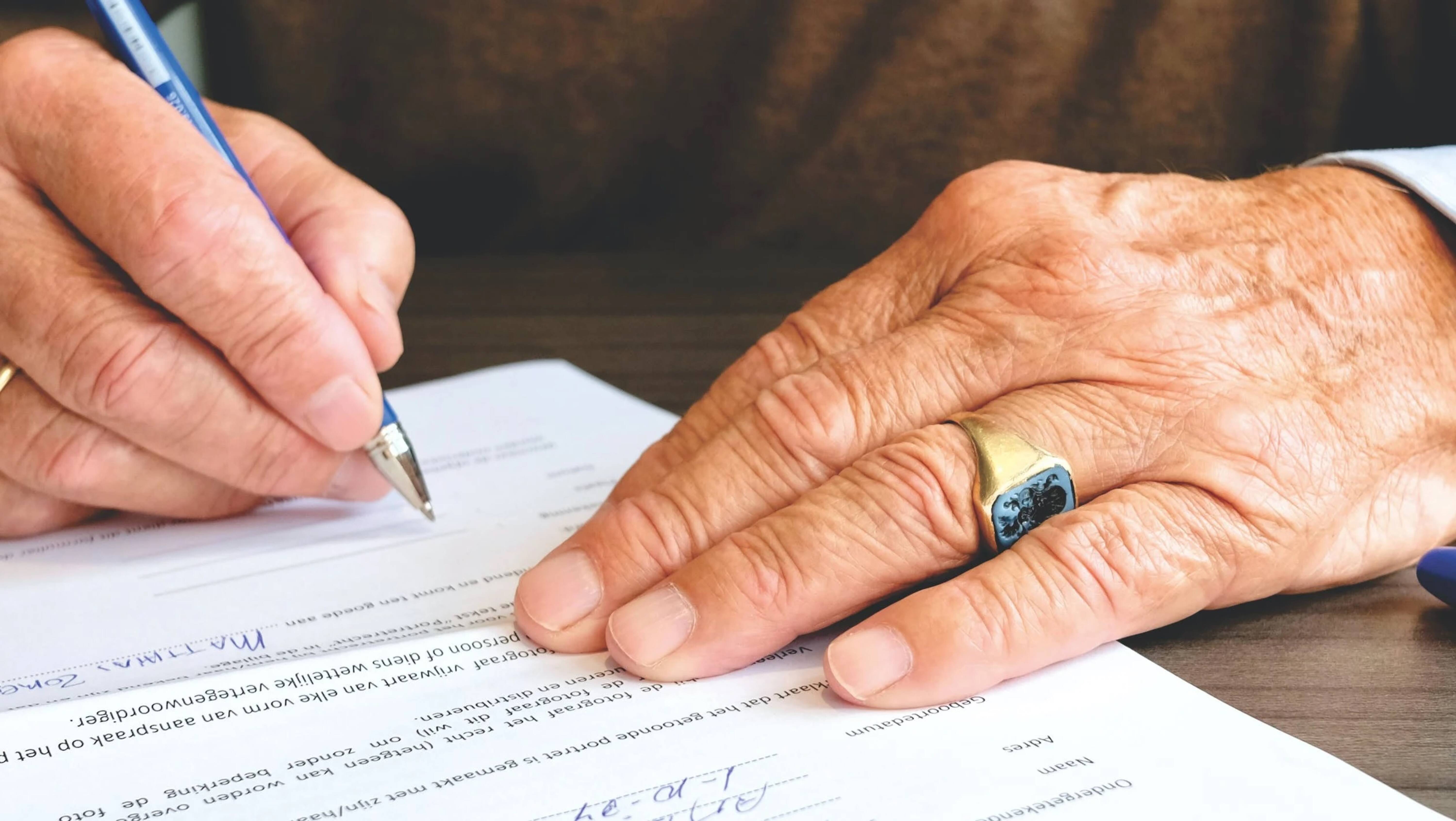  A close-up of a man signing a contract.
