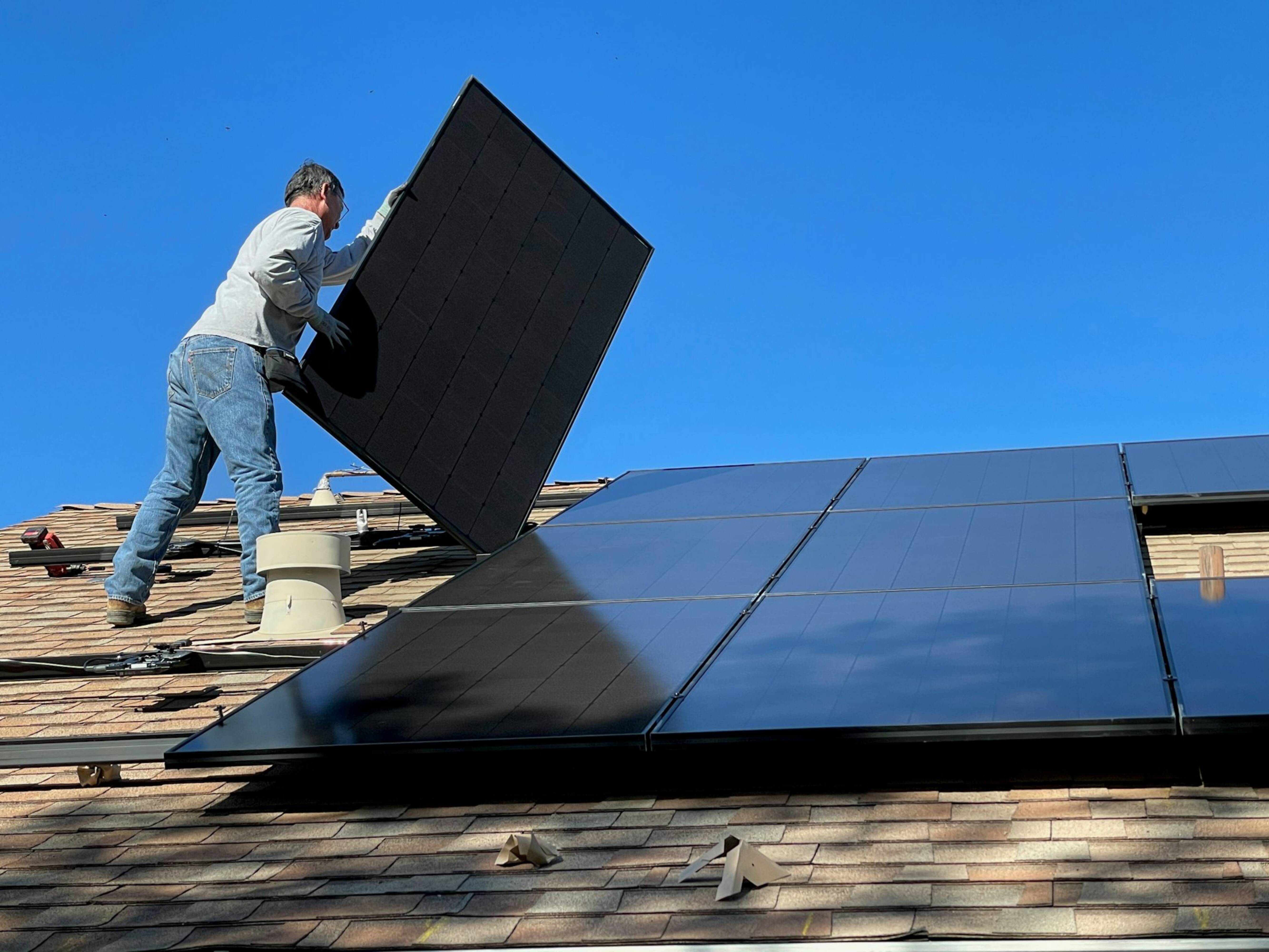 Setting up solar panels on a roof
