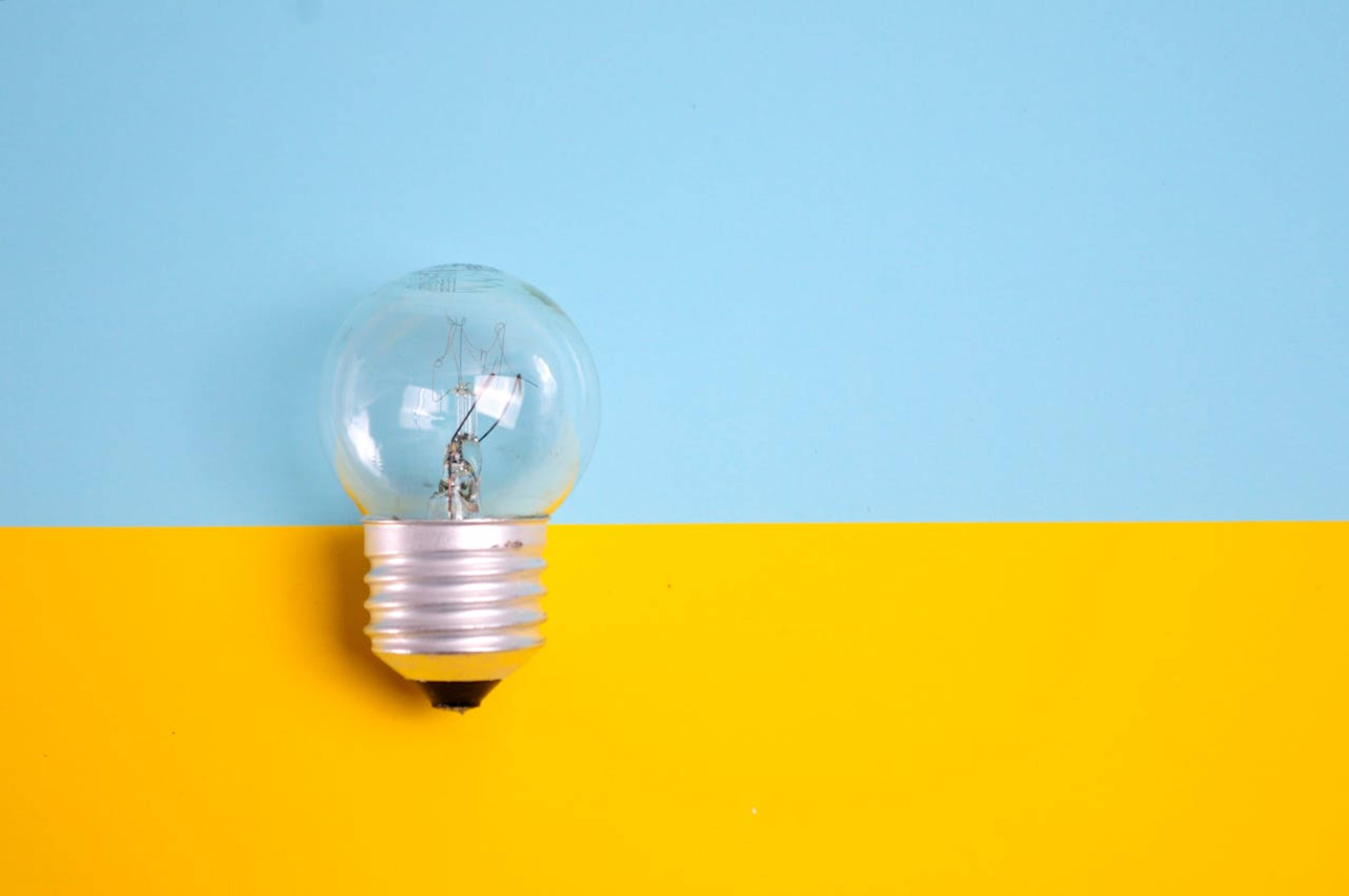 A lightbulb on a yellow and blue surface