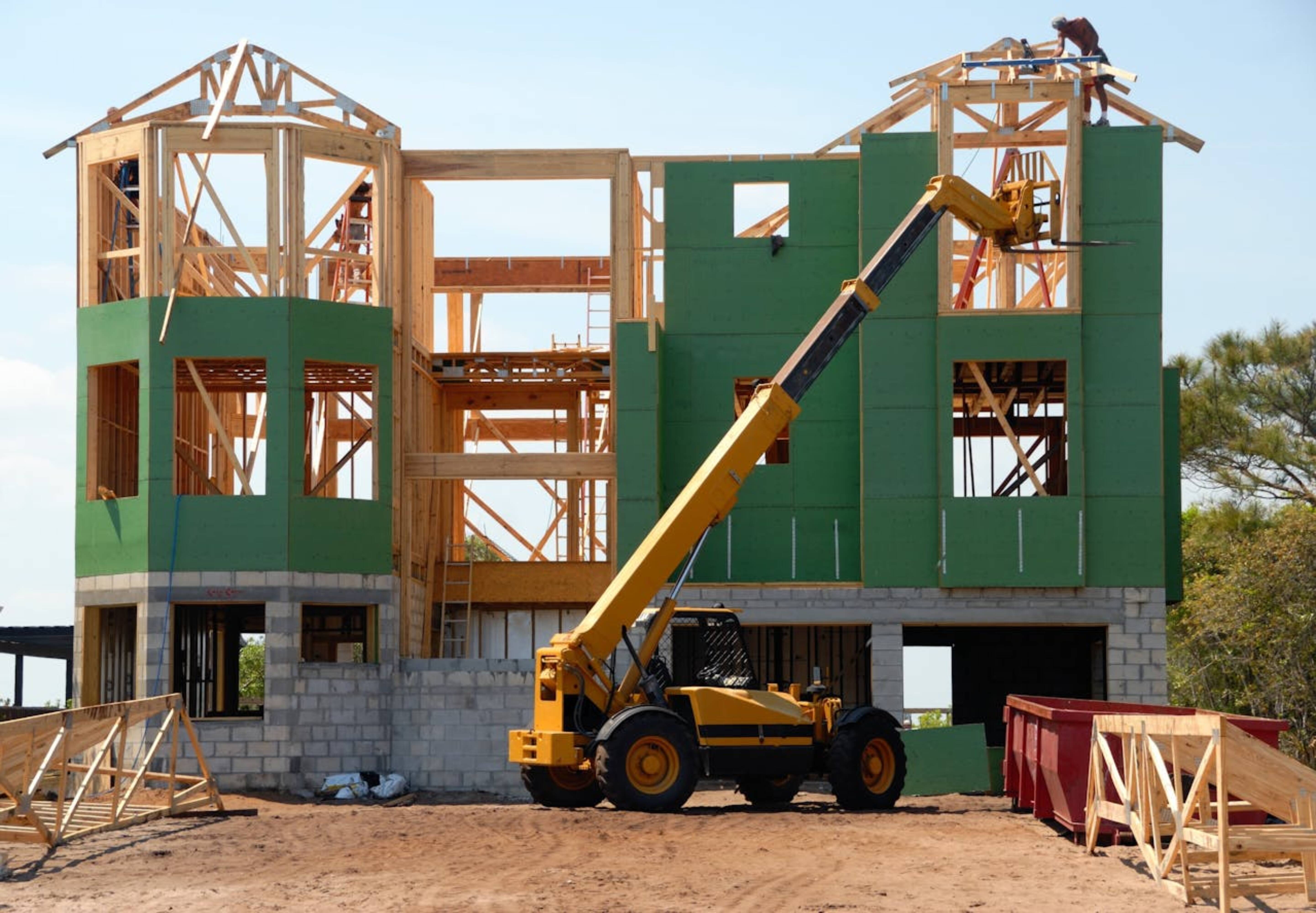 Heavy equipment and machinery in front of a house that’s being built.