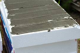 Insulation of facade wall with styrofoam sheets. Polystyrene insulation boards with glue adhesive Insulation of facade wall with styrofoam sheets. Polystyrene insulation boards with glue adhesive